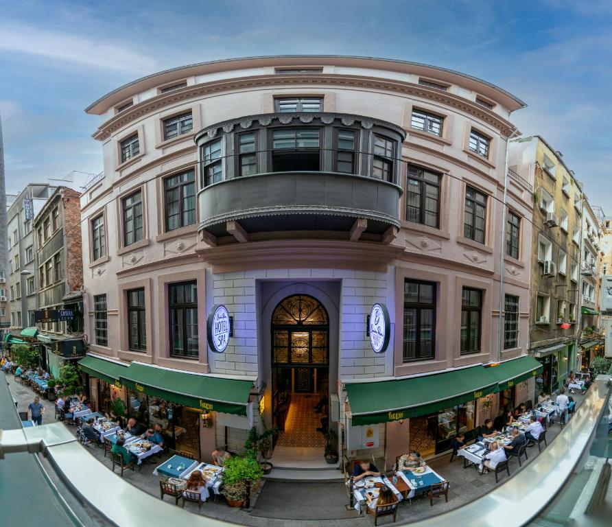een gebouw met tafels en stoelen ervoor bij Elmira Pera Hotel & - Special Class in Istanbul