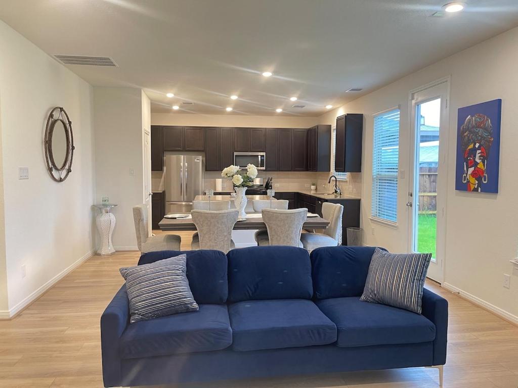 a living room with a blue couch and a kitchen at Vees home away from home in Rosharon
