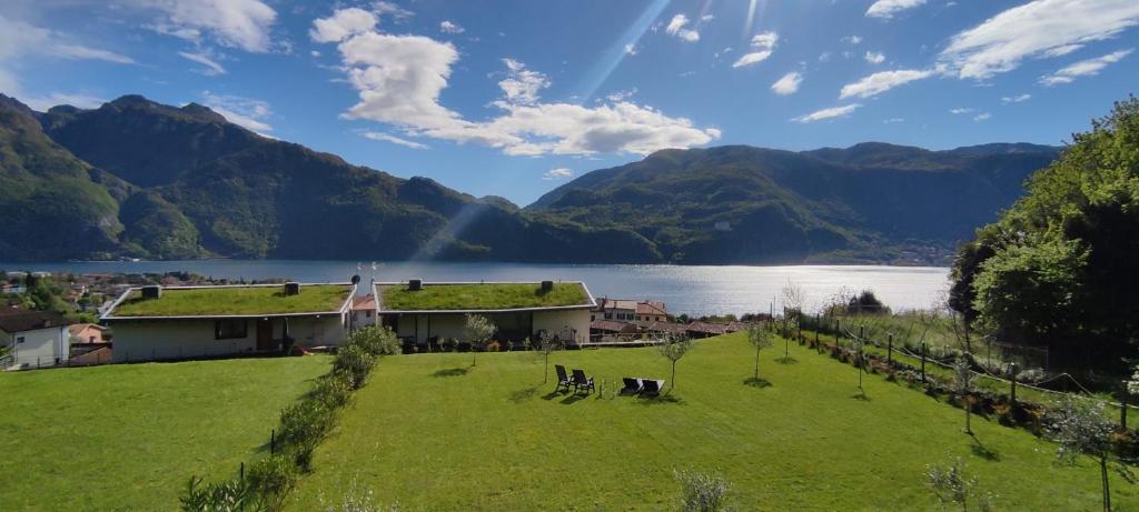 a building with a grassy field next to a lake at Villa Raggio di Sole in Abbadia Lariana