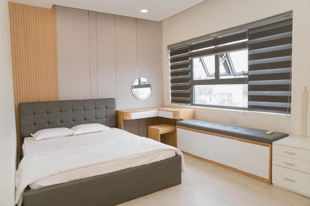 a bedroom with a large bed and a window at Aria Seaside Apartment - Căn hộ nghỉ dưỡng 3PN sát biển in Vung Tau