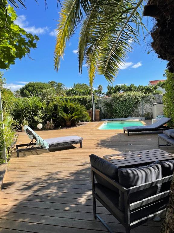 a patio with benches and a swimming pool at L 'Évasion in Saint-Cyprien