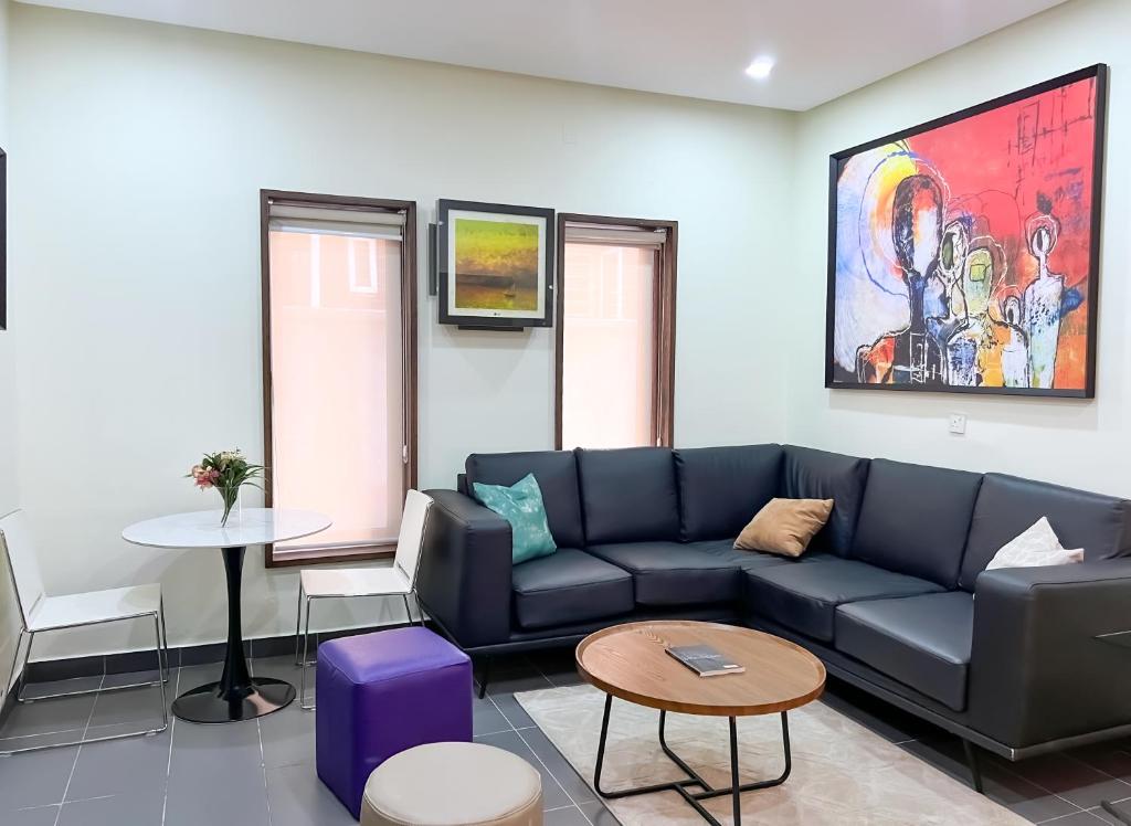 una sala de estar con un sofá y una mesa en Serene Heights Hotel, en Maiyegun