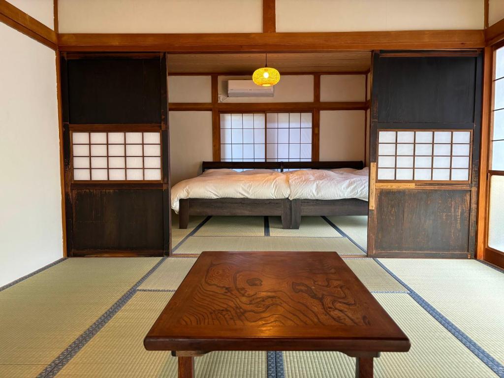 ŌwadaにあるHostel Inn かすみがうら 仁左ェ門のベッドとテーブルがある部屋