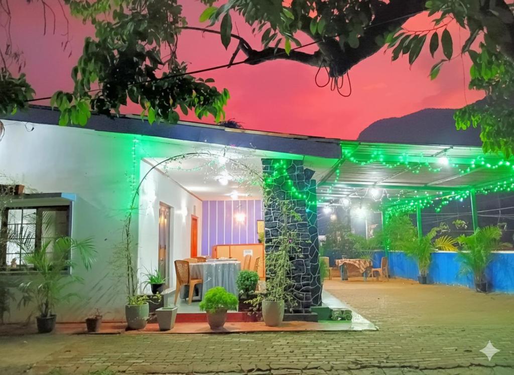 a house with green lights on the facade at NK Hotel and Restaurant in Matale
