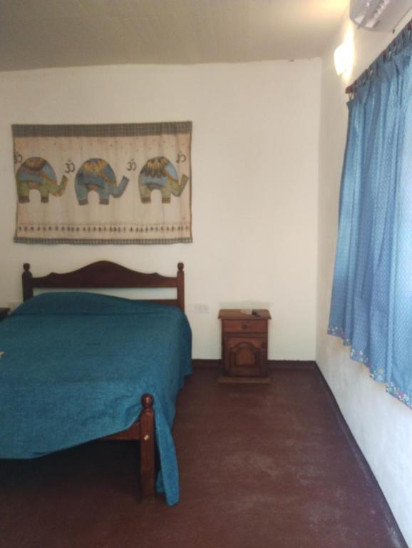 a bedroom with a bed with a blue bedspread at Zelenaiplava dormis in Merlo