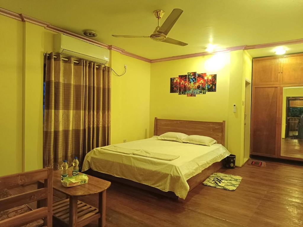 a bedroom with a bed and a ceiling fan at Green Zone Cottage 