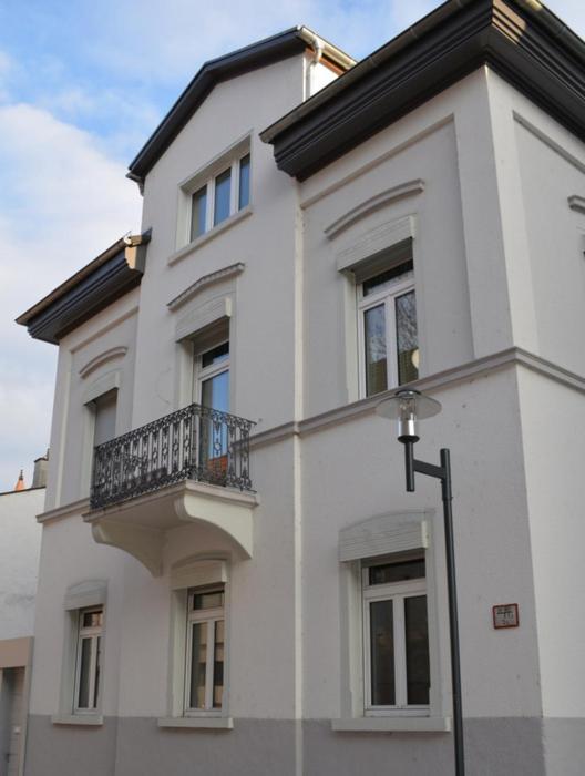 a white building with a balcony on top of it at Schmuckstück an der Wormser Stadtmauer in Worms