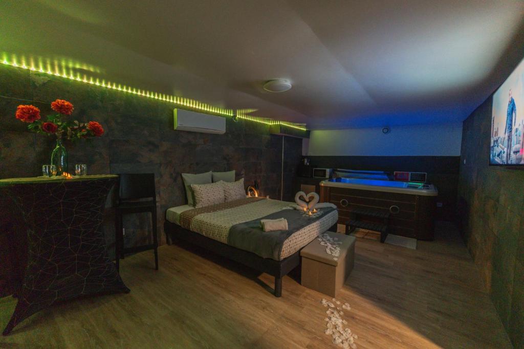 a room with a bed and a desk and a bed sidx sidx sidx at Suite Tentation avec Jacuzzi in Châteauneuf-lès-Martigues