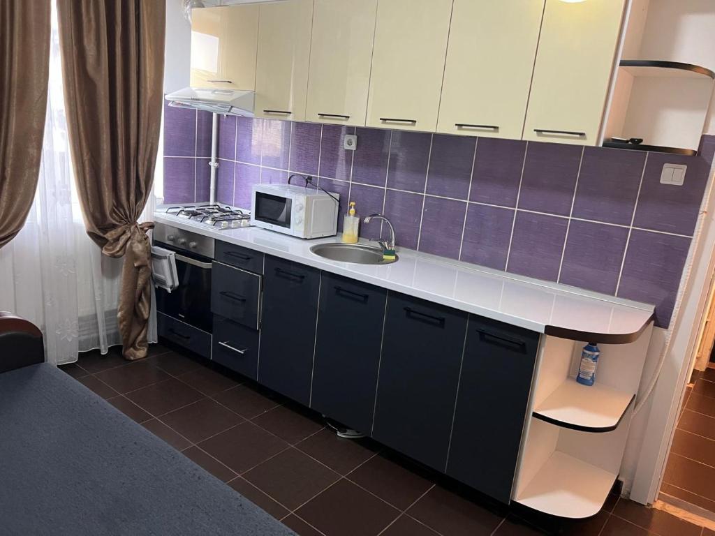 una cucina con lavello e microonde di Alex Apartment a Balş