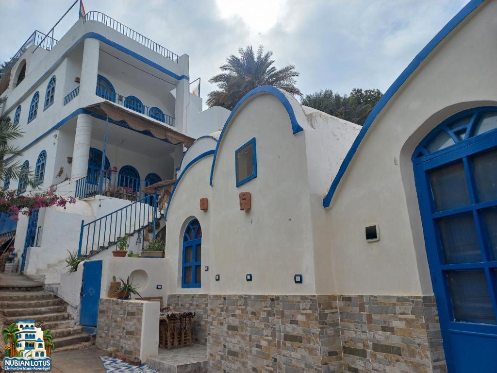 un edificio blanco y azul con puertas azules en Nubian Lotus, en Asuán