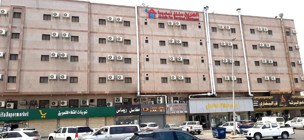a large building with cars parked in front of it at شقق العرين للشقق المخدومة in Jeddah