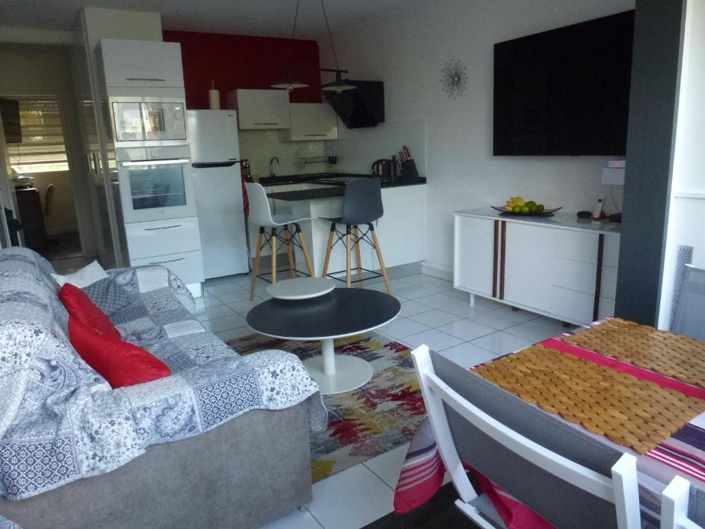 Una sala de estar y una cocina con un sofá y una mesa. en Bonite, en Les Trois-Îlets