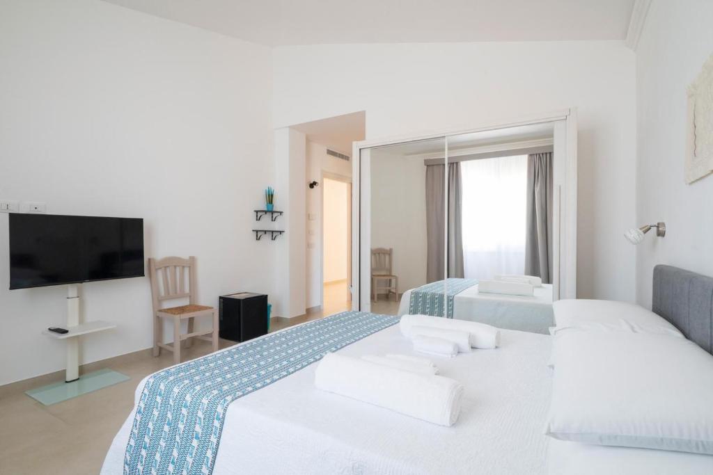 a bedroom with two beds and a flat screen tv at I Centenari Longevity Rooms in Lotzorai