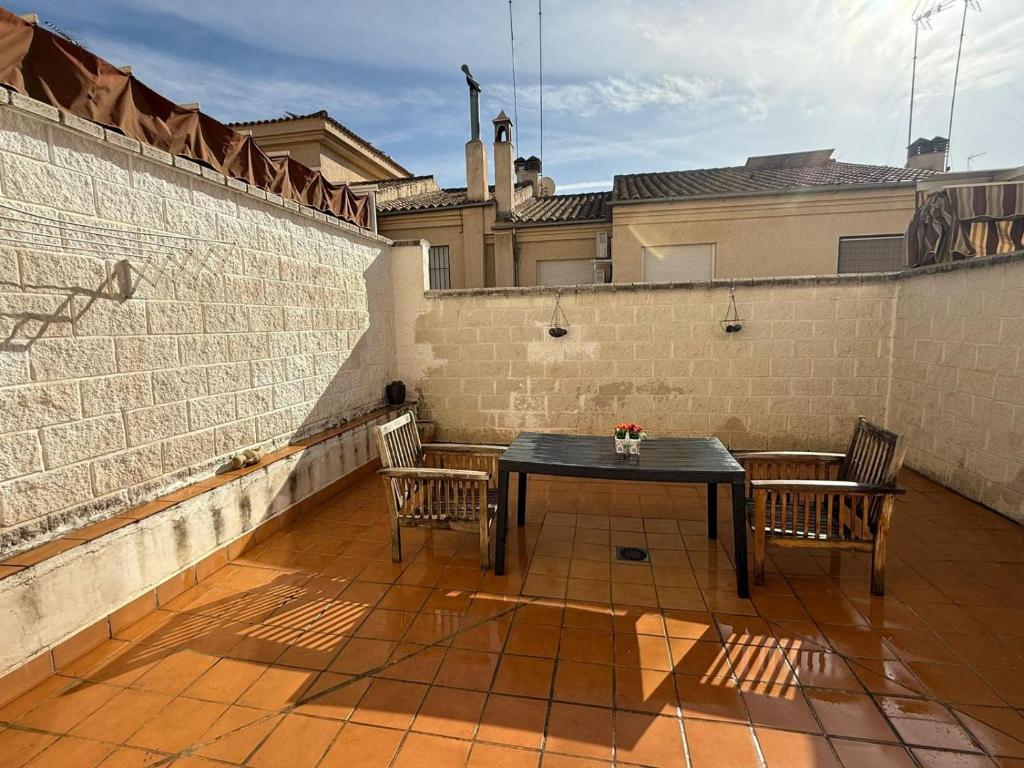 een patio met een tafel en 2 stoelen op een dak bij Casa Familiar Atarfe in Atarfe