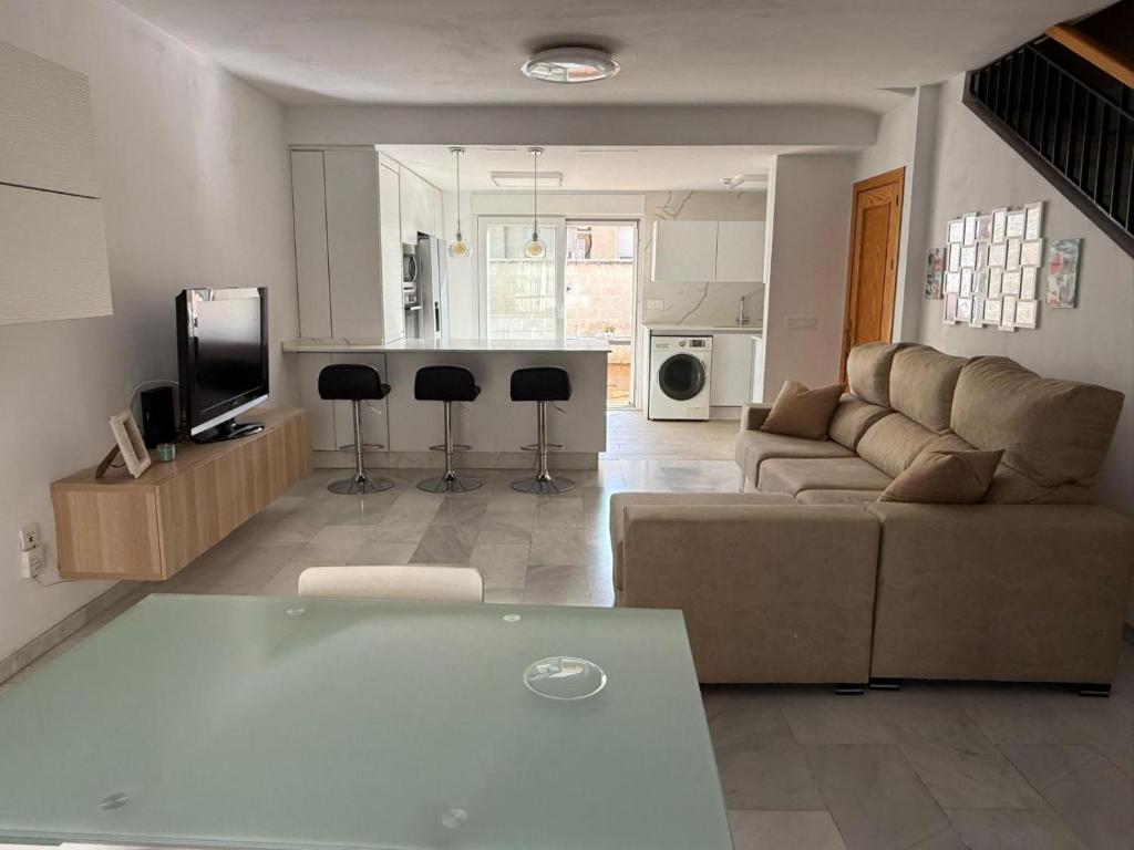 a living room and kitchen with a couch and a table at Casa Familiar Atarfe in Atarfe