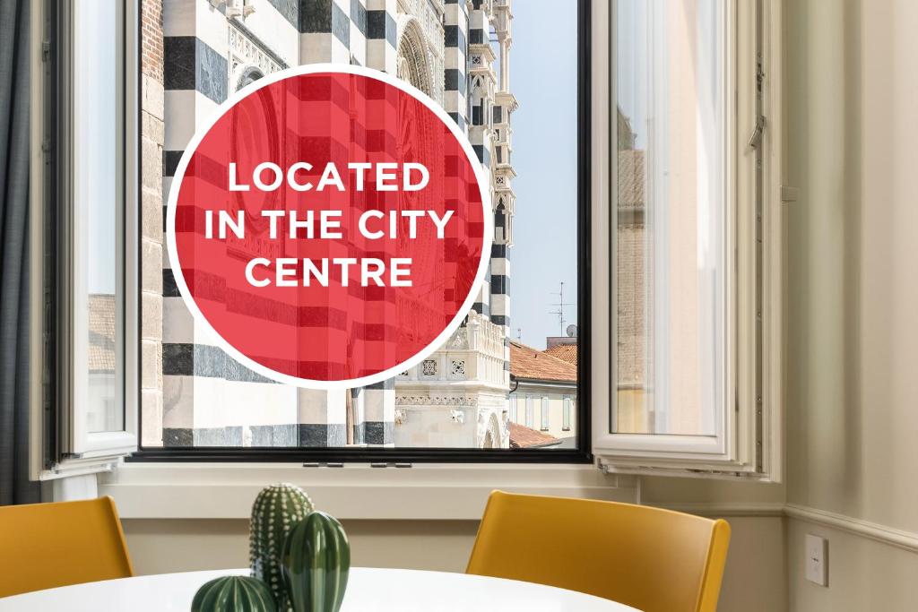 a sign in a window with a sign located in the city centre at Casa Duomo Luxury Suites in Monza