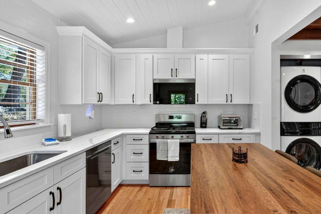 a kitchen with white cabinets and a wooden counter top at Spacious cabin w private river, hot tub & fire pit in Harpers Ferry