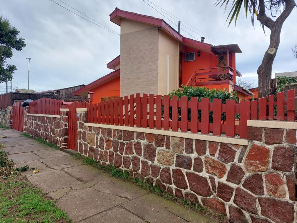 uma cerca vermelha na frente de uma casa em Playas de Quintero em Quintero