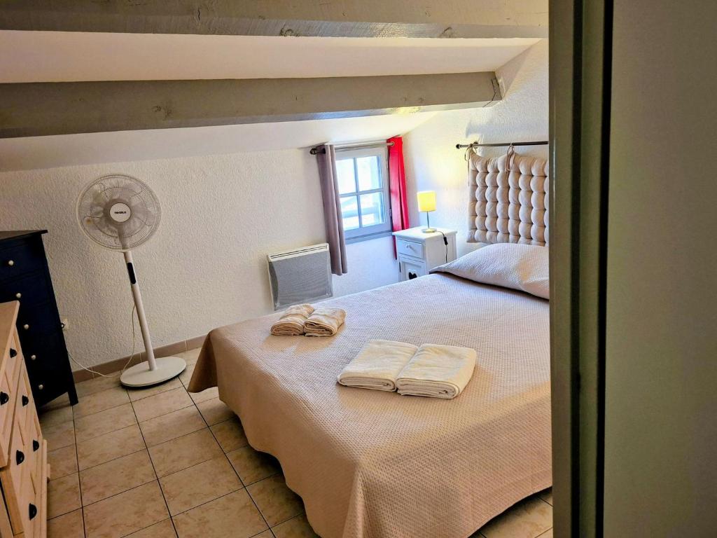 Grand appart proche des plages Parking privé في سانت ماري دو لا مير: غرفة نوم بها سرير عليه منشفتان