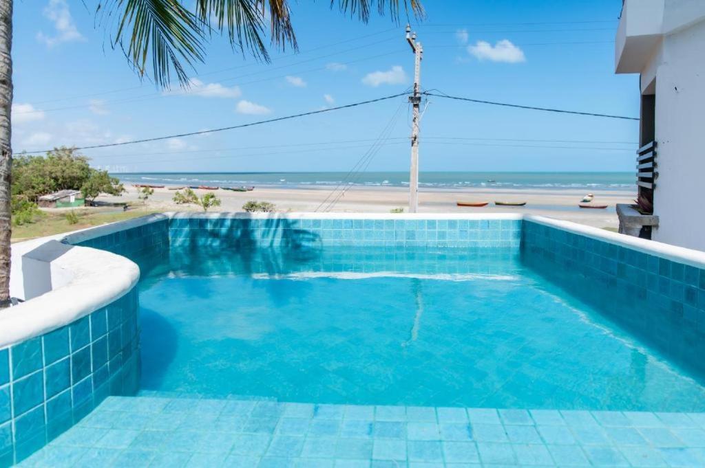 a swimming pool with a view of the beach at Casa Maria Areia Boutique in Camocim