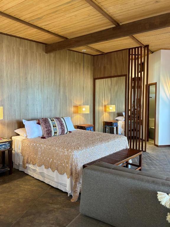 a bedroom with a bed and a couch at Casa Maria Areia Boutique in Camocim