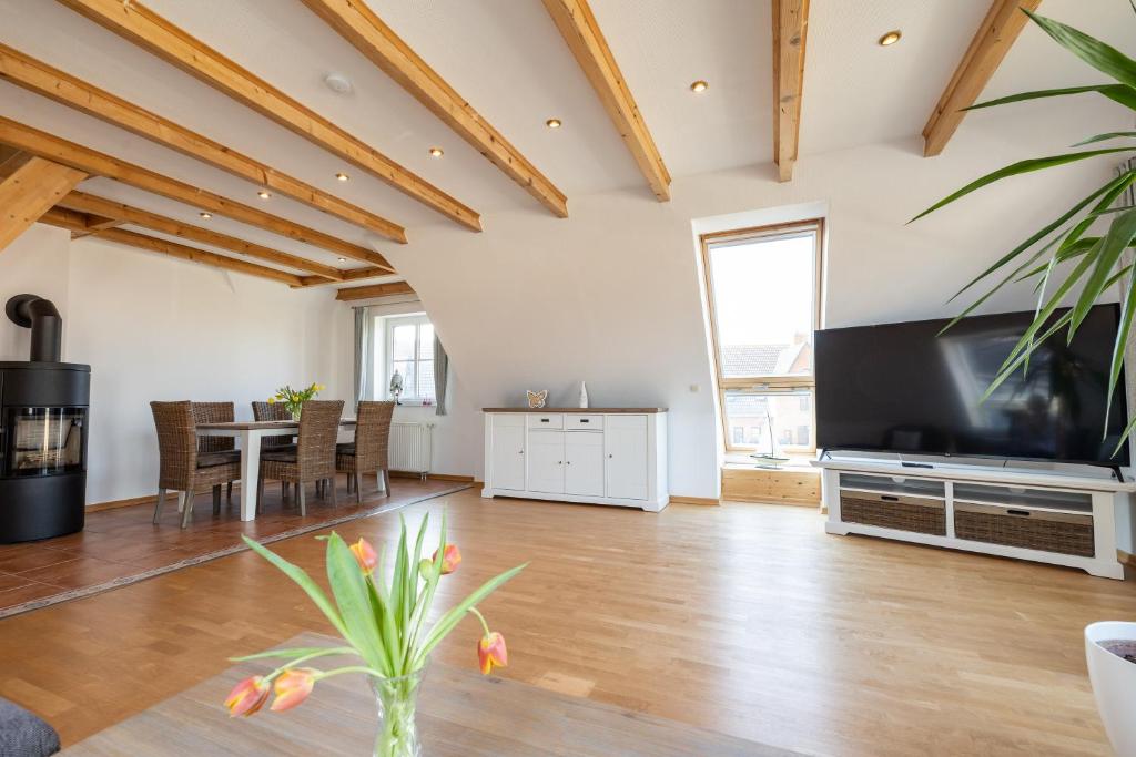 un soggiorno con una grande televisione e un tavolo di Haus "Zur Düne" a Norddorf