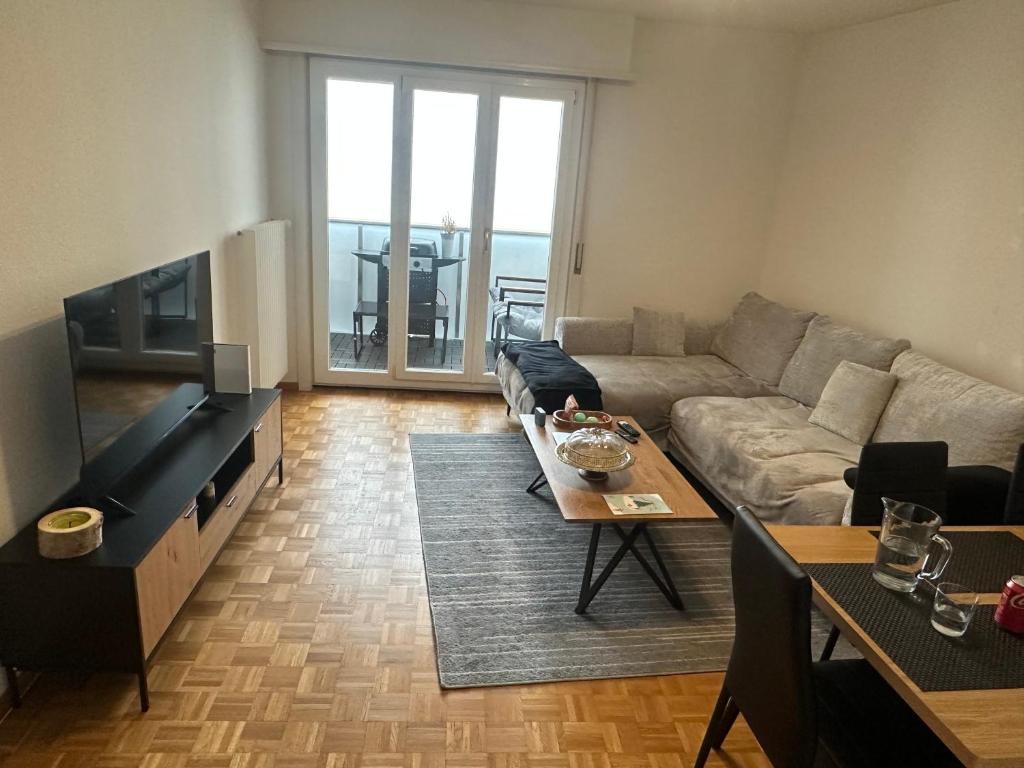 a living room with a couch and a table at chambre in Neuchâtel
