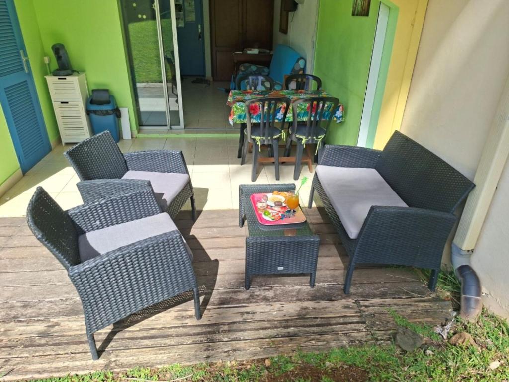 d'une terrasse avec quatre chaises, une table et une table. dans l'établissement Ty Alice, à Sainte-Anne