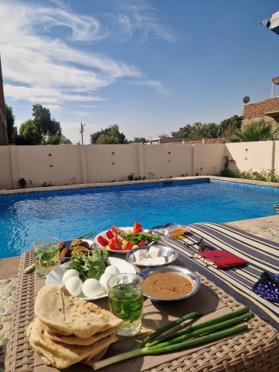 a tray of food on a table next to a swimming pool at Morsy Palace in Luxor