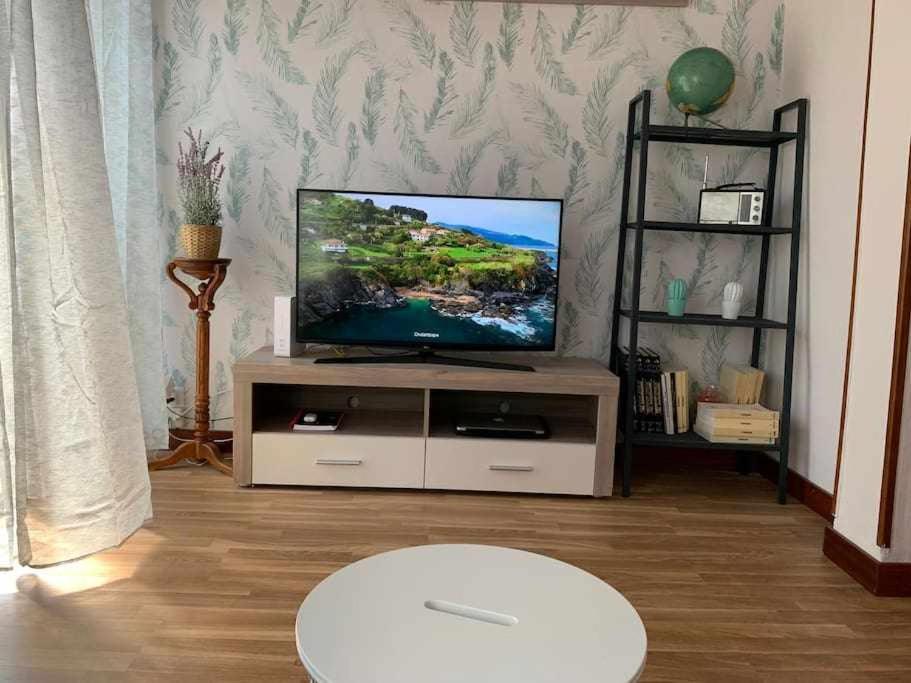 a living room with a flat screen tv on a stand at Singular piso junto al puerto - Arostegi Etxea in Bermeo