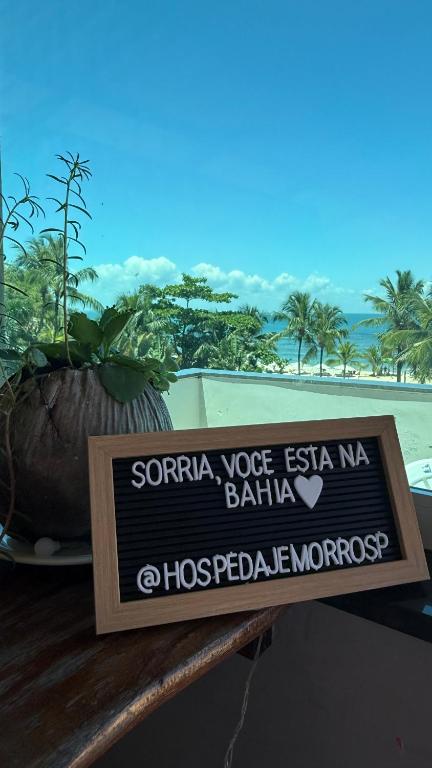a sign on a table in front of a beach at Hospedaje MorroSP in Morro de São Paulo