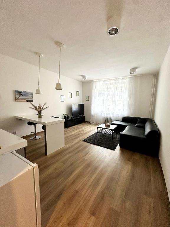 a living room with a black couch and a table at CenterPoint Apartment in Karlovy Vary