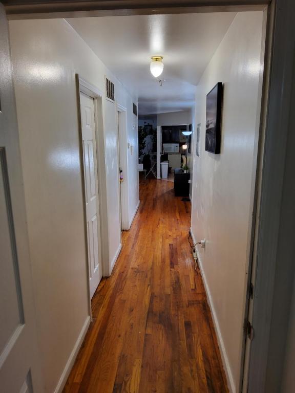 a hallway with white walls and a hard wood floor at Abiel Global Concepts LLC in Newark