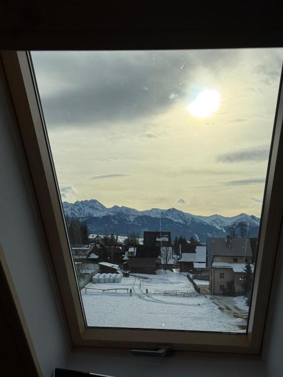 a window with a view of a snow covered city at Tatrzański Widok na góry, Jacuzzi, Sauna, parking in Biały Dunajec