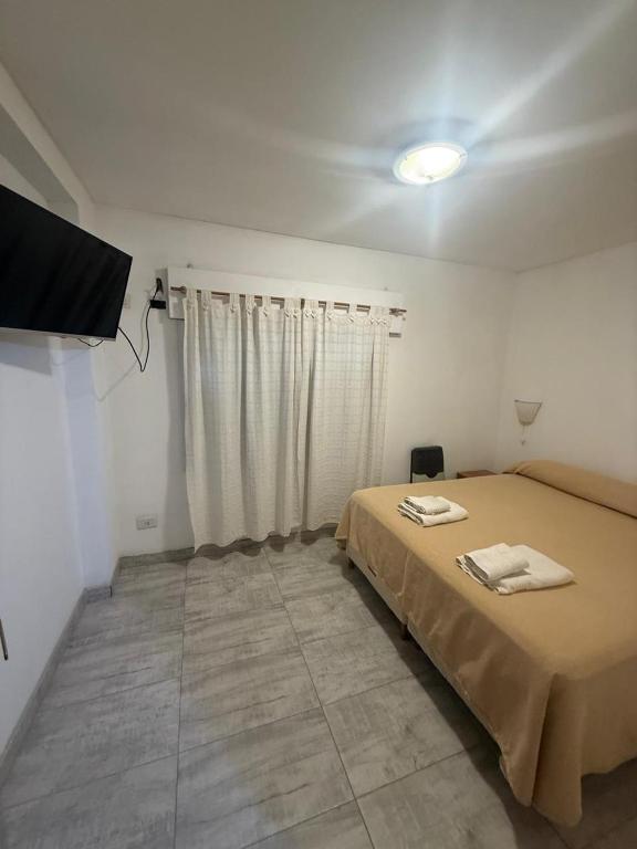 a bedroom with a bed and a flat screen tv at Apart Hotel Posta Marina in San Antonio Oeste