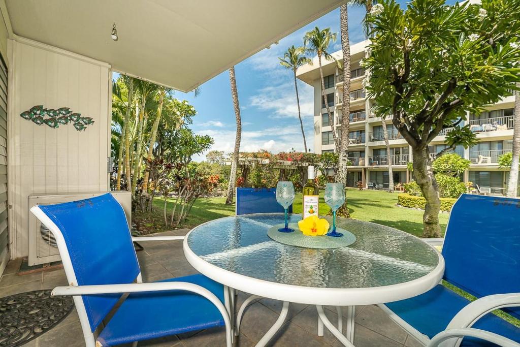 un patio con tavolo e sedie e un edificio di Kihei Akahi B102 a Wailea