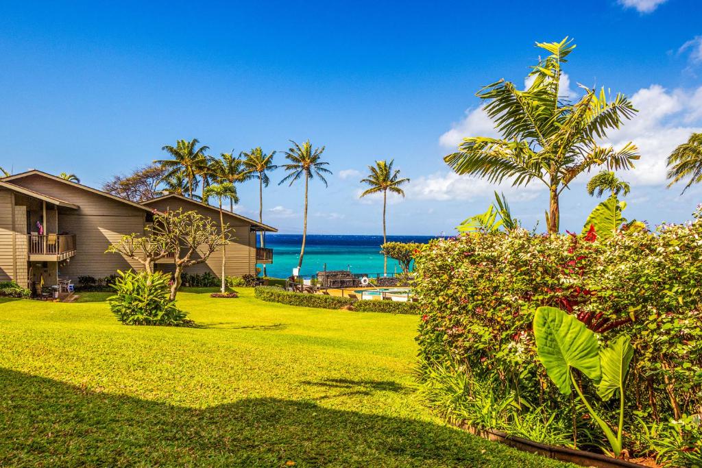 un cortile con palme, una casa e l'oceano di Polynesian Shores 112 a Kahana