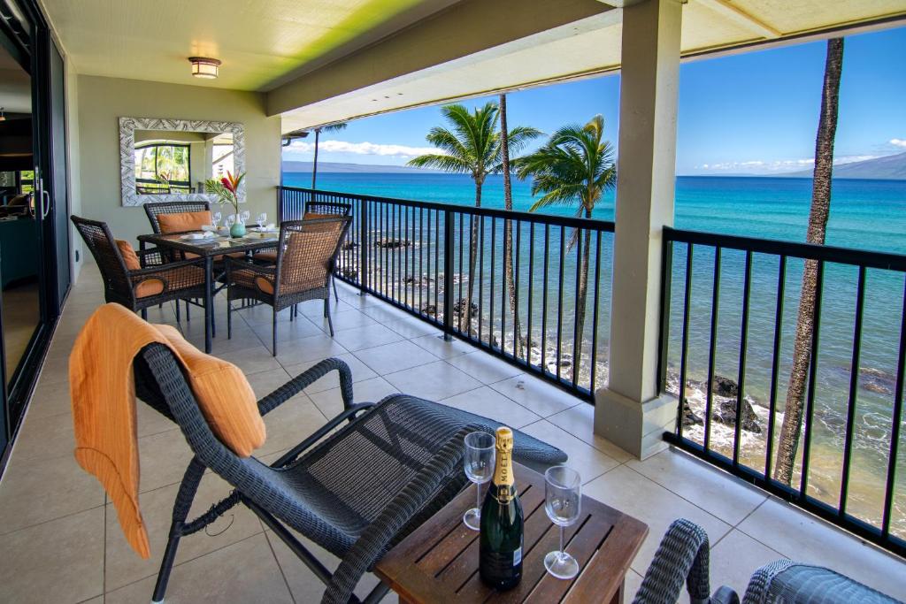 Noelani 410 في Kapalua-West Maui Airport: شرفة مع طاولة وكراسي والمحيط
