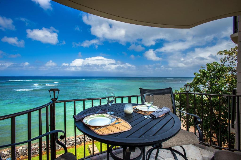 a table and chairs on a balcony with the ocean at Kahana Reef 321 in Kahana