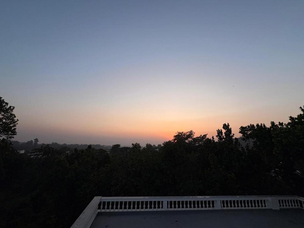a sunset from the roof of a house at Retrova - Forest Villa near Rajpur Road in Rājpur
