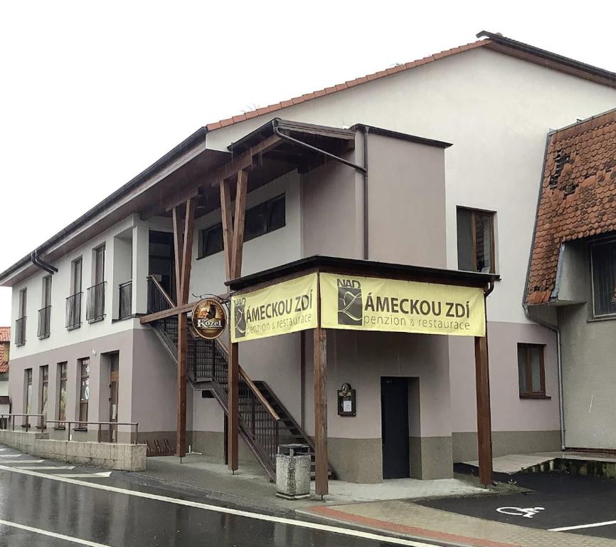 Un edificio blanco con un cartel al costado. en Penzion Nad Zámeckou zdí, en Trhový Štěpánov