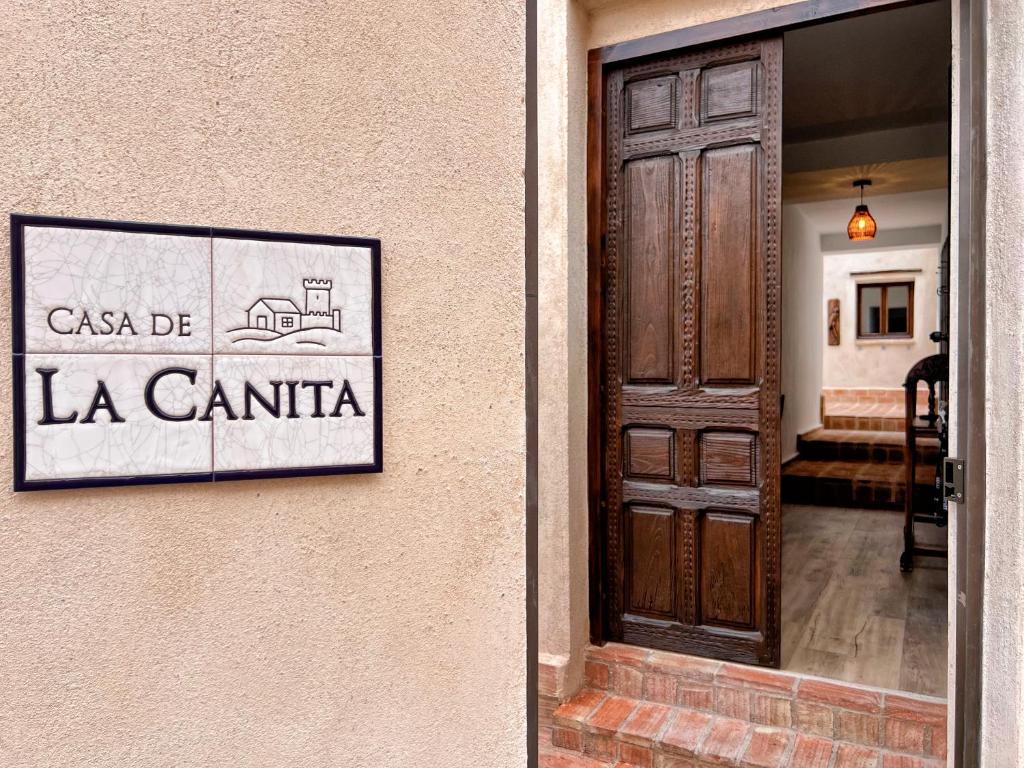 een deur naar een gebouw met een bordje waarop 'la cantina' staat bij Casa de La Canita in Guadamur