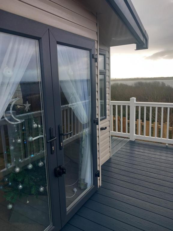 eine Glastür zu einer Terrasse mit Balkon in der Unterkunft The Bluebell in Haverigg