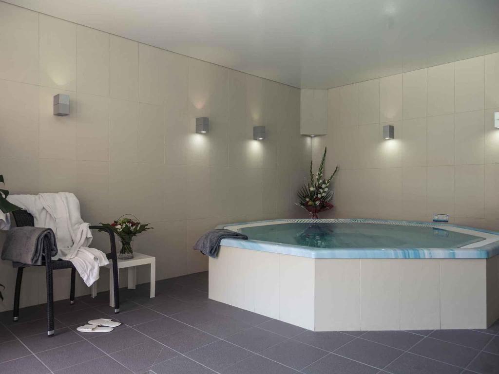 a bathroom with a large tub in a room at Mercure Dinan Port Le Jerzual in Dinan
