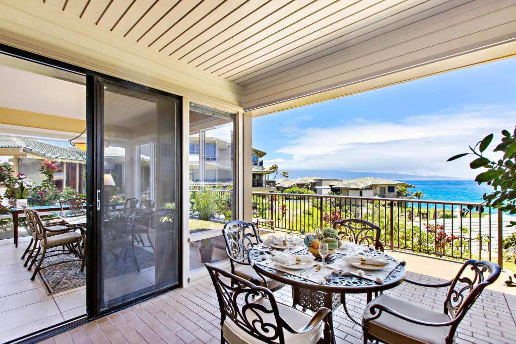a dining table on a patio with a view of the ocean at Kapalua Bay Villa 24G2 in Honokahua