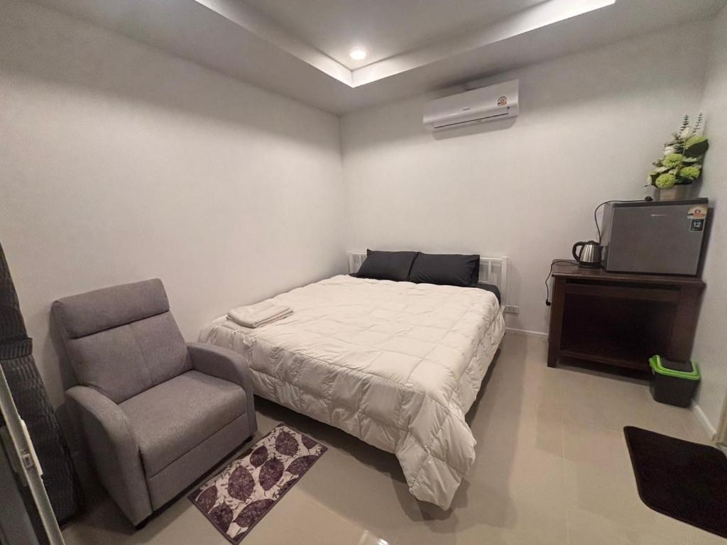 a bedroom with a bed and a chair at Mong Do Lay Baan Sea View in Ban Ao Makham