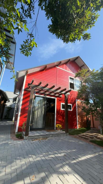 a red building with a red wall at Morada dos Butiás in Imbituba