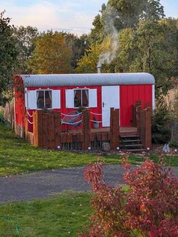 a red and white trailer with smoke coming out of it at Auszeit im Bauwagen in Arnsdorf