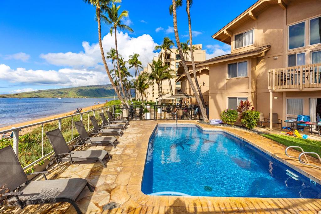 a house with a swimming pool next to a beach at Kihei Sands B2 in Kihei