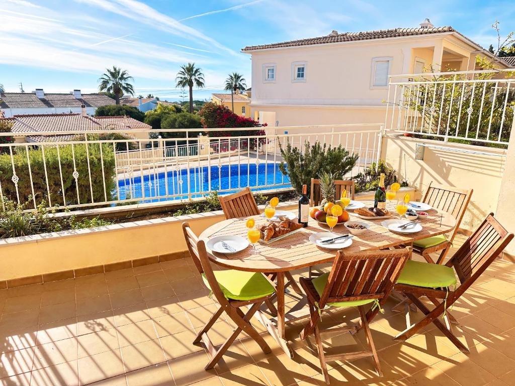 un tavolo e sedie su un balcone con piscina di Balaia Maggs House Pool & Ocean view by BeCherish a Branqueira
